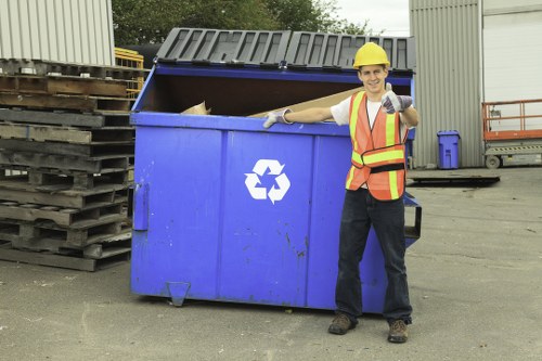 Operative wearing PPE while sorting business waste on site